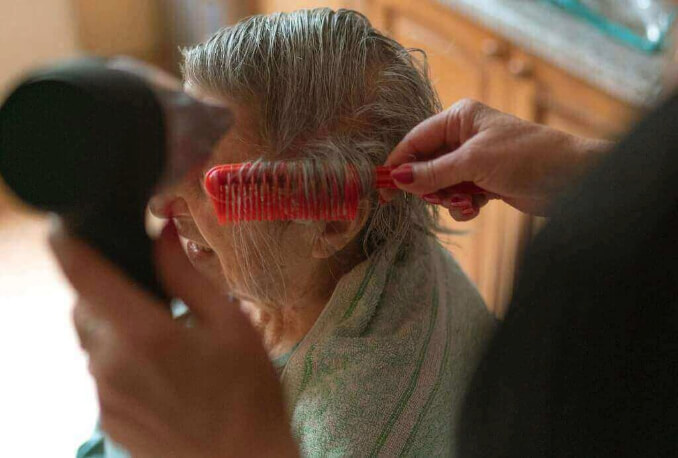 Cuidadora penteando a idosa